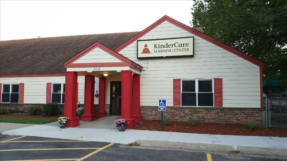 A beige building with red trim and a KinderCare Learning Center sign