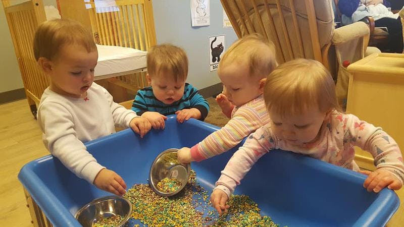 Four children playing with sensory bin