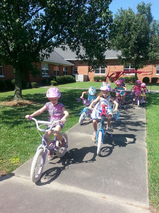 Children riding bicycles on a sidewalk