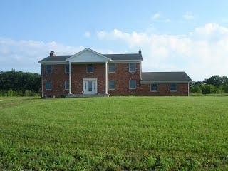 Brick house with white columns and a large green lawn