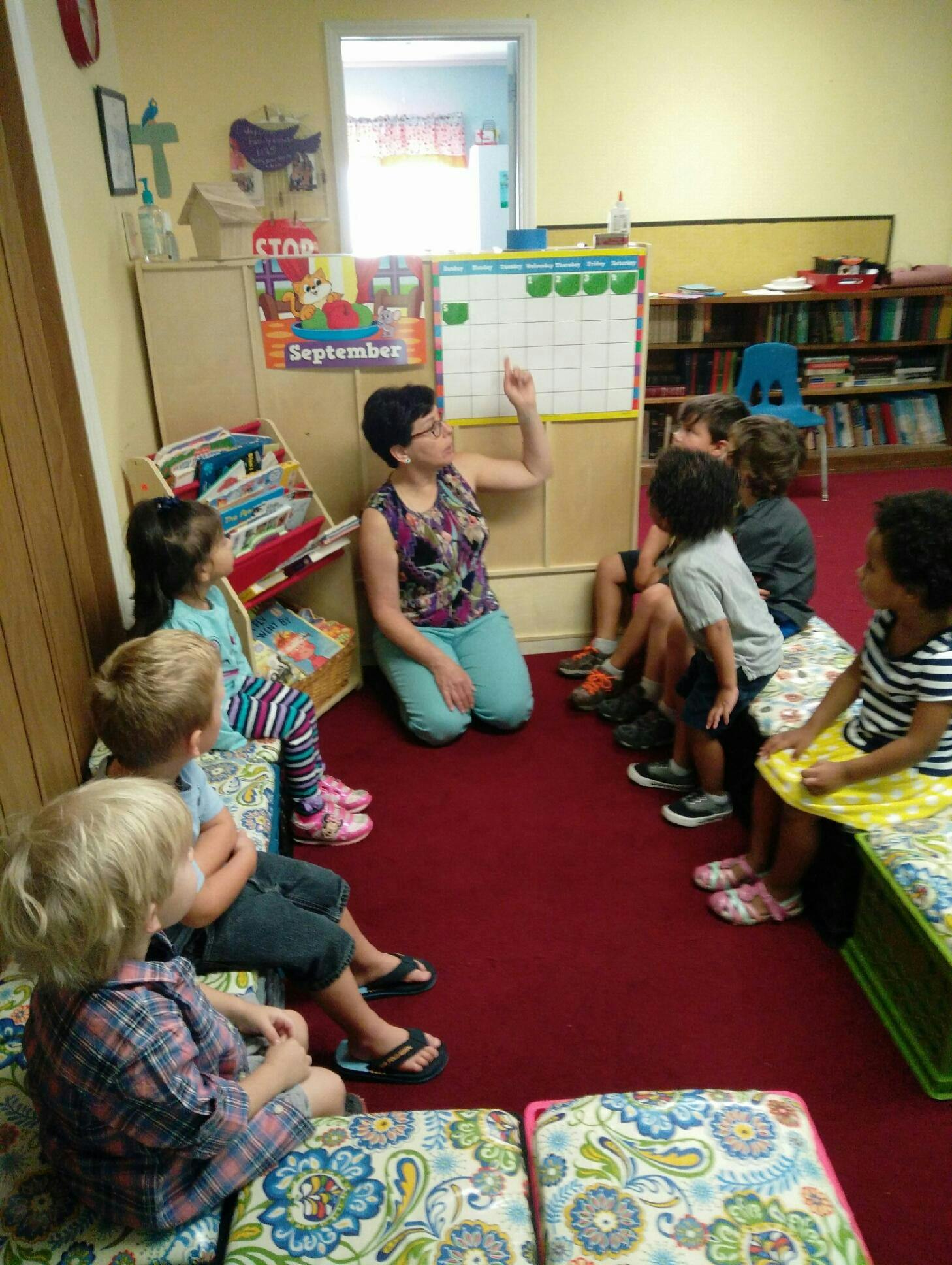 Adult teaching a group of children in a classroom