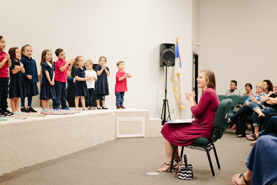 Children on a stage performing for an audience