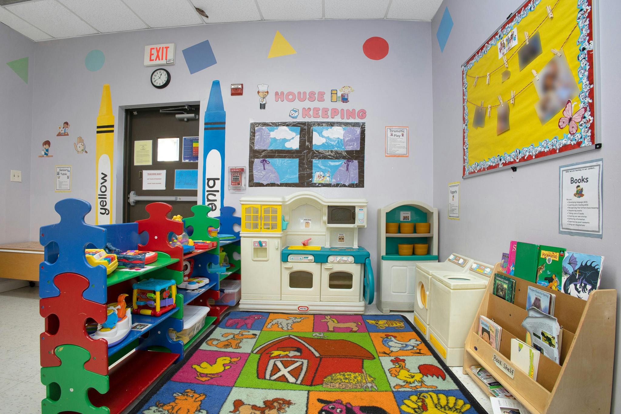 Colorful playroom with toy kitchen, bookshelf, and a play rug