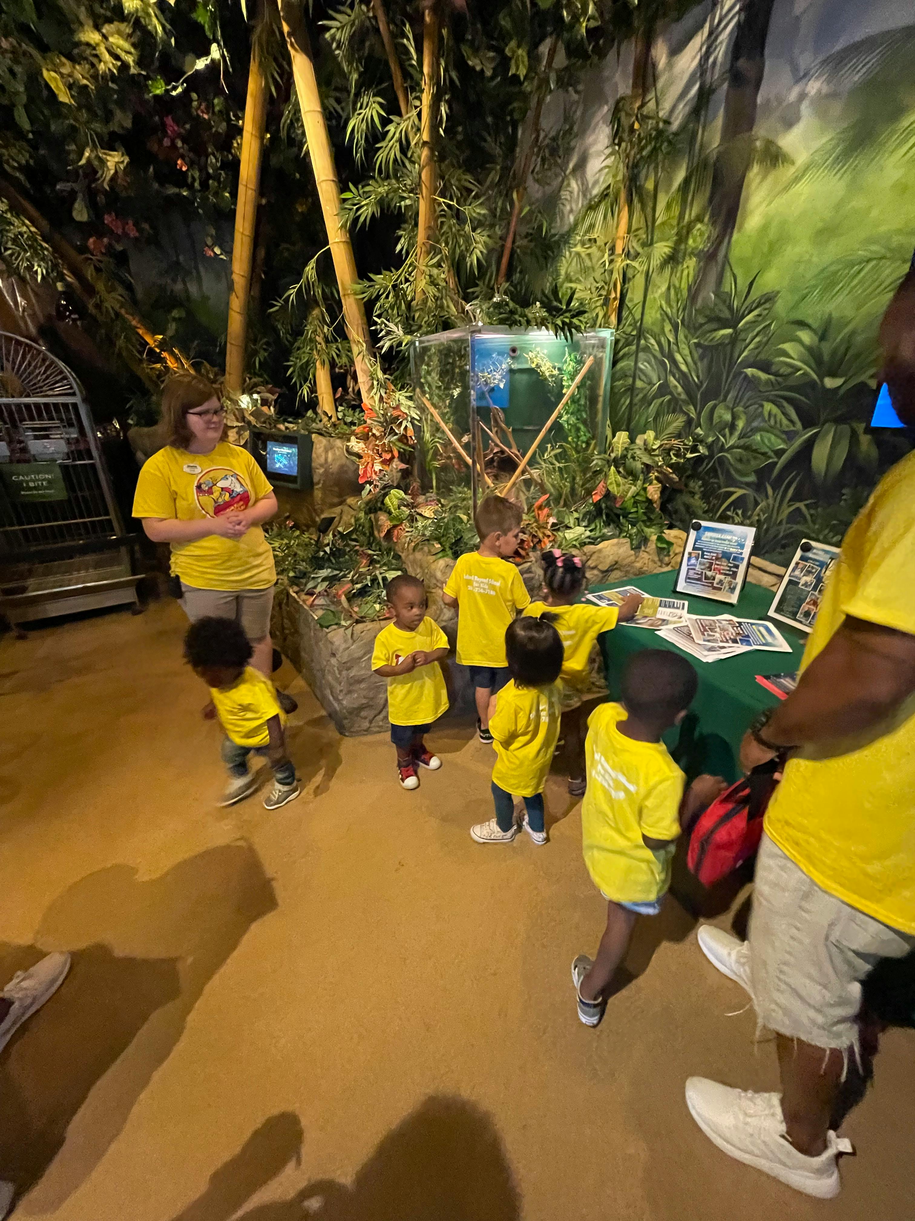 Adult and children in yellow shirts gathered around a table