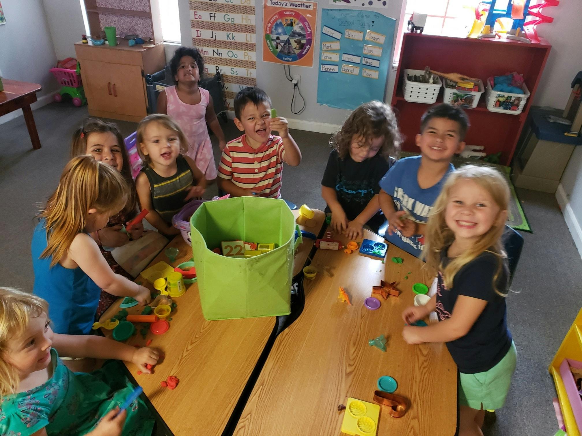 Children playing with toys at a table in a classroom