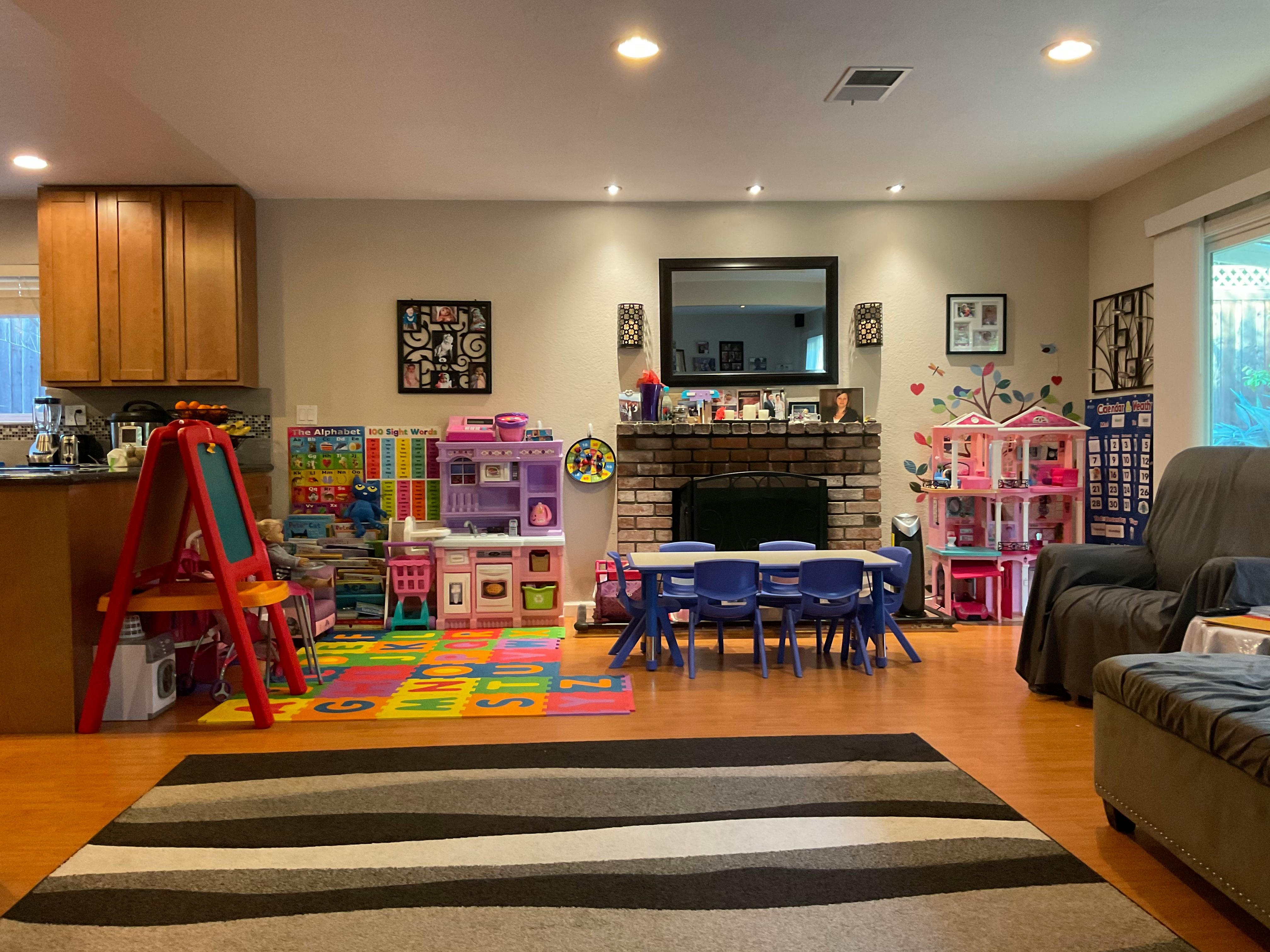 Living room with children's play area, fireplace, and television