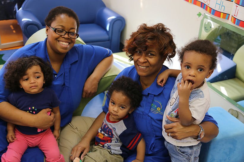 Two people in blue shirts with three children
