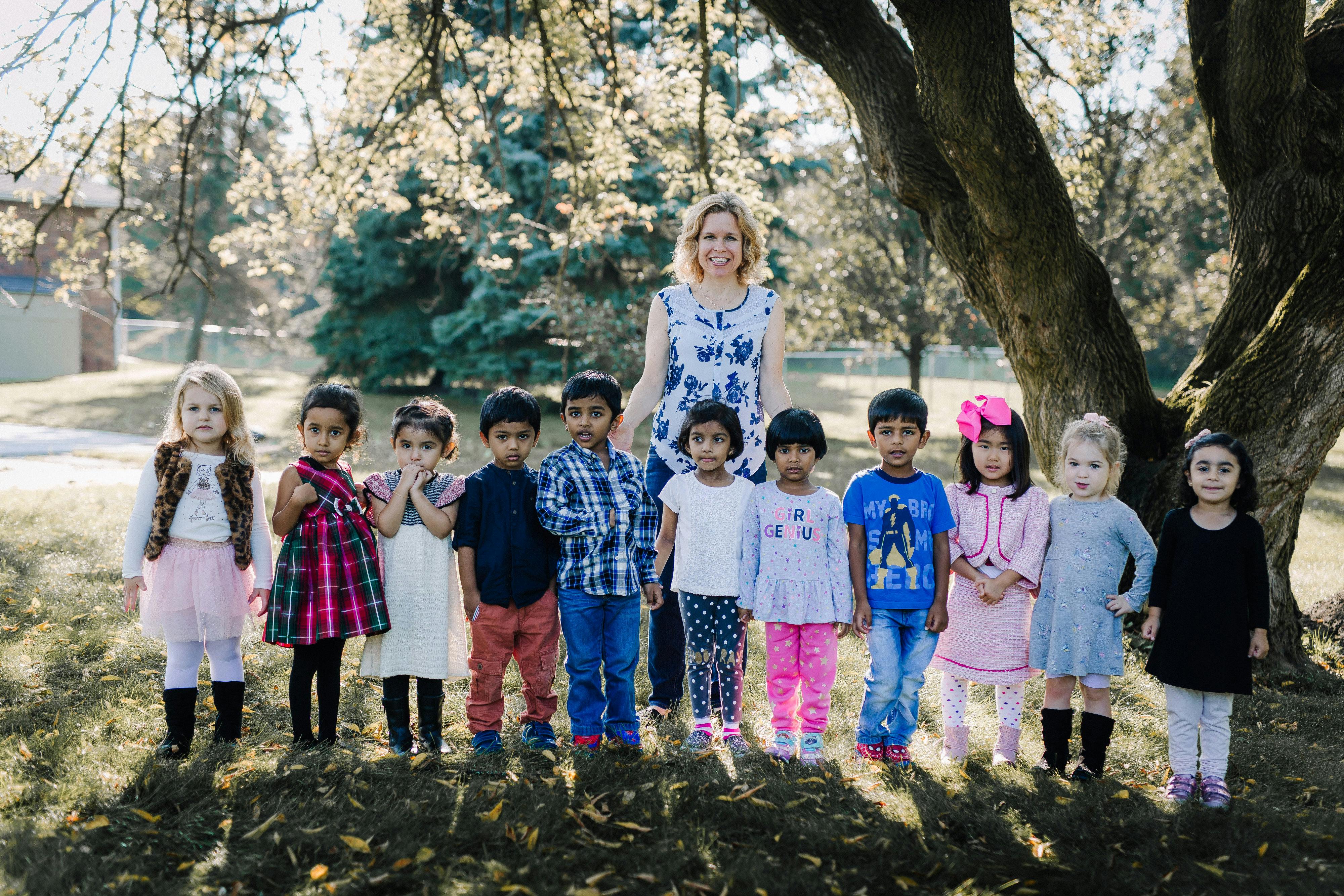 Adult and group of children standing outdoors
