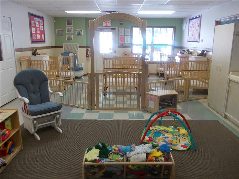 Baby room with multiple cribs, a glider chair, and play mats