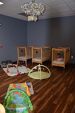 Nursery room with multiple cribs and play mats
