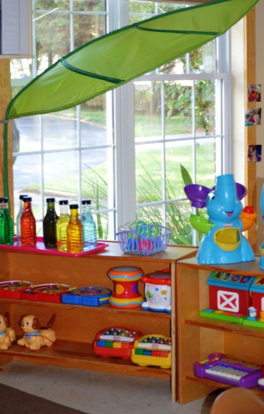 Classroom window with bottles, toys, and a green fabric leaf decoration