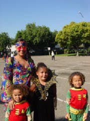 Adult and three children in costumes standing outdoors