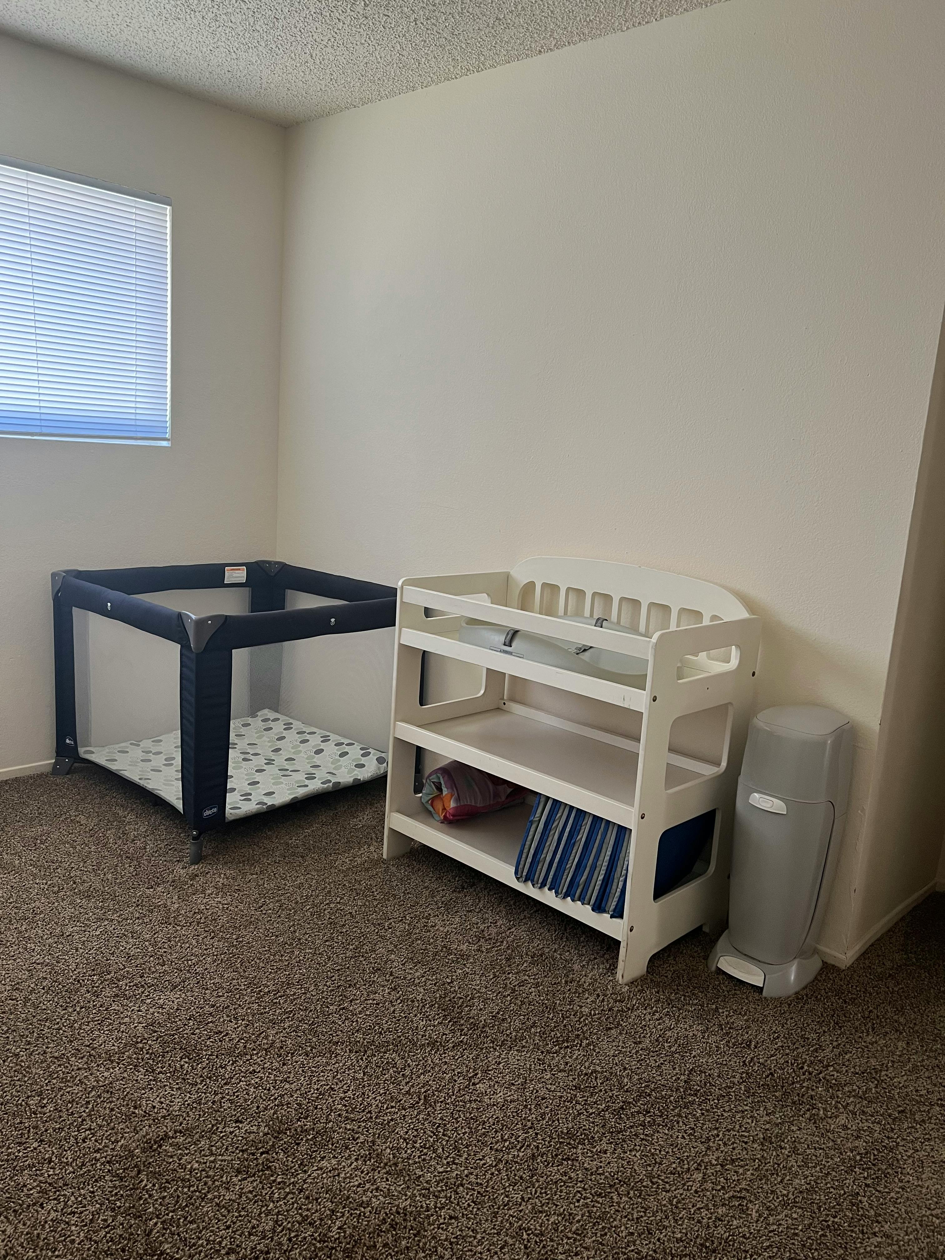 Playpen and changing table in a room
