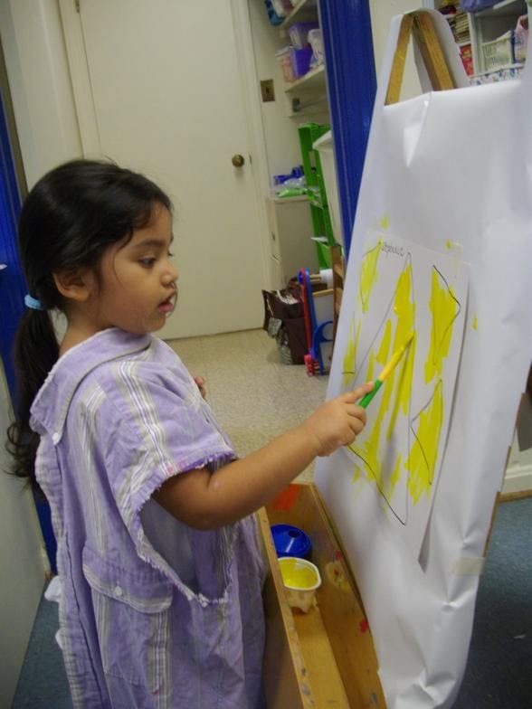 Child painting on an easel
