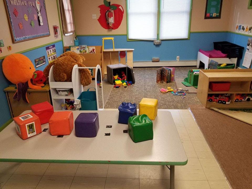 Playroom with colorful blocks on a table and toys scattered on the floor