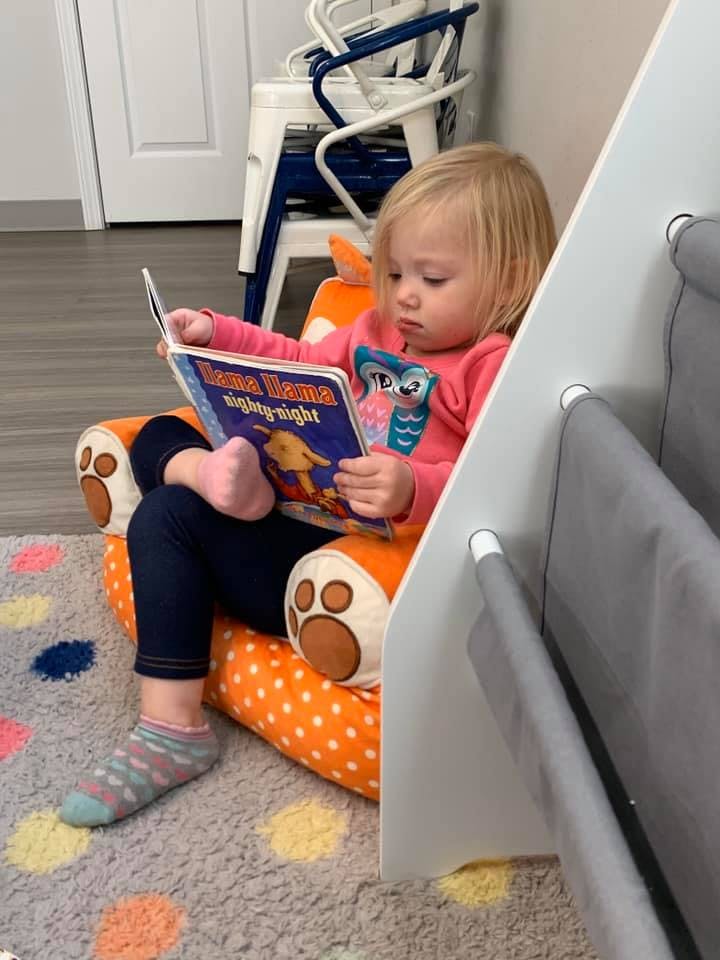 Child sitting in a chair reading a book
