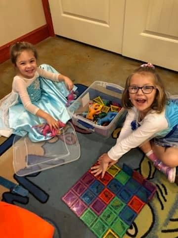Two children playing with toys on a rug
