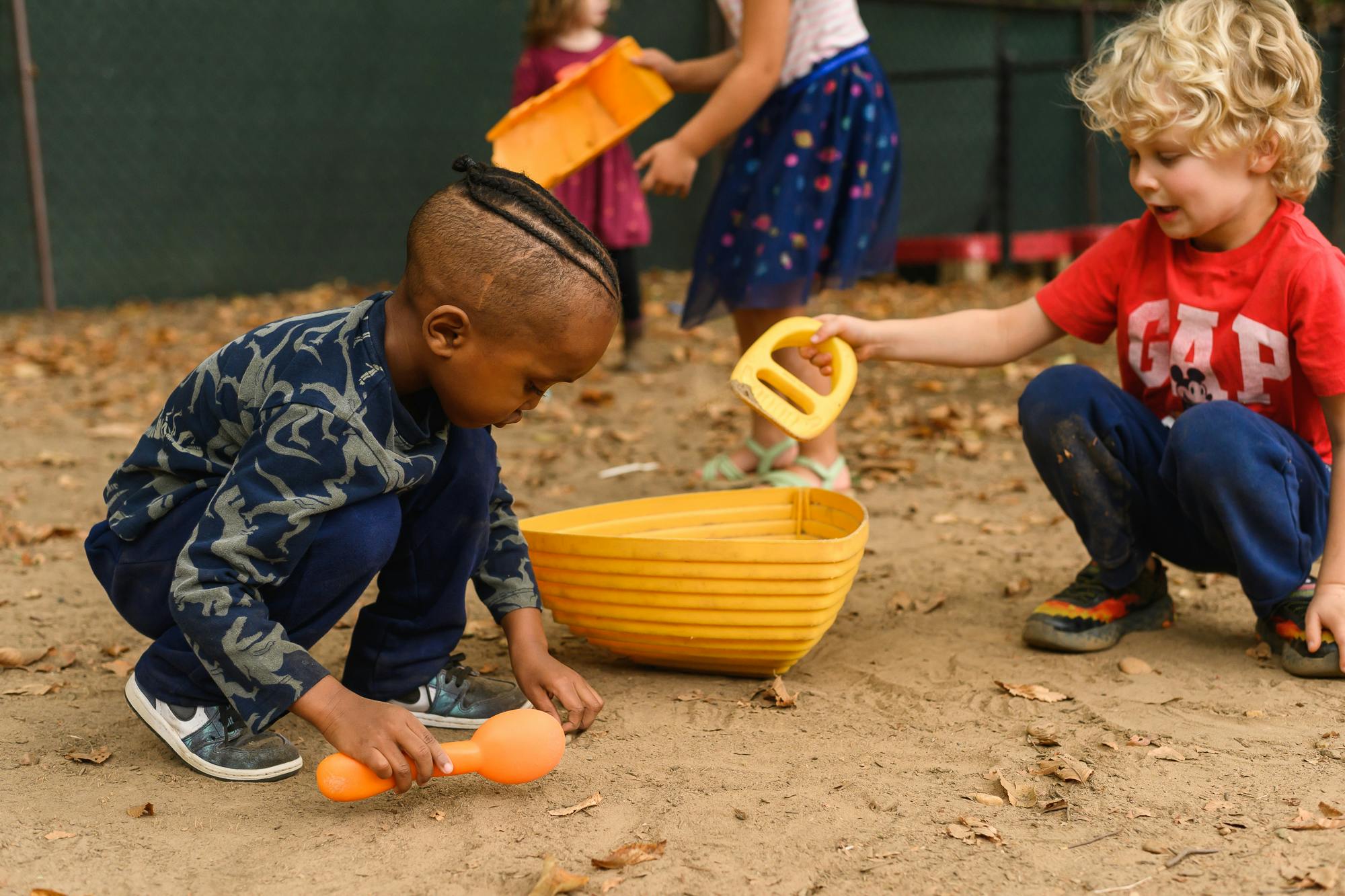Children playing in sand with toys