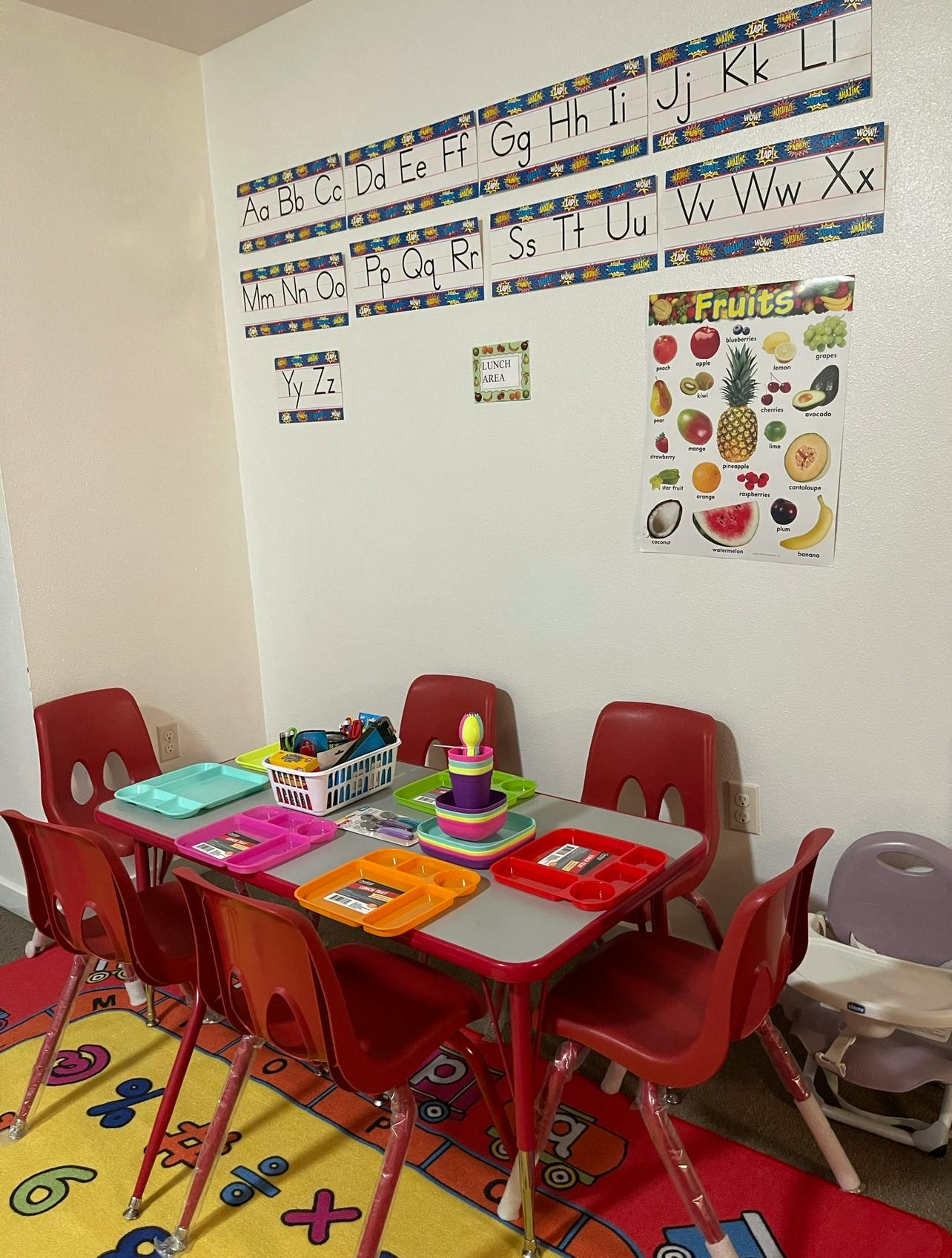 Classroom with alphabet charts, fruit poster, and small table with chairs
