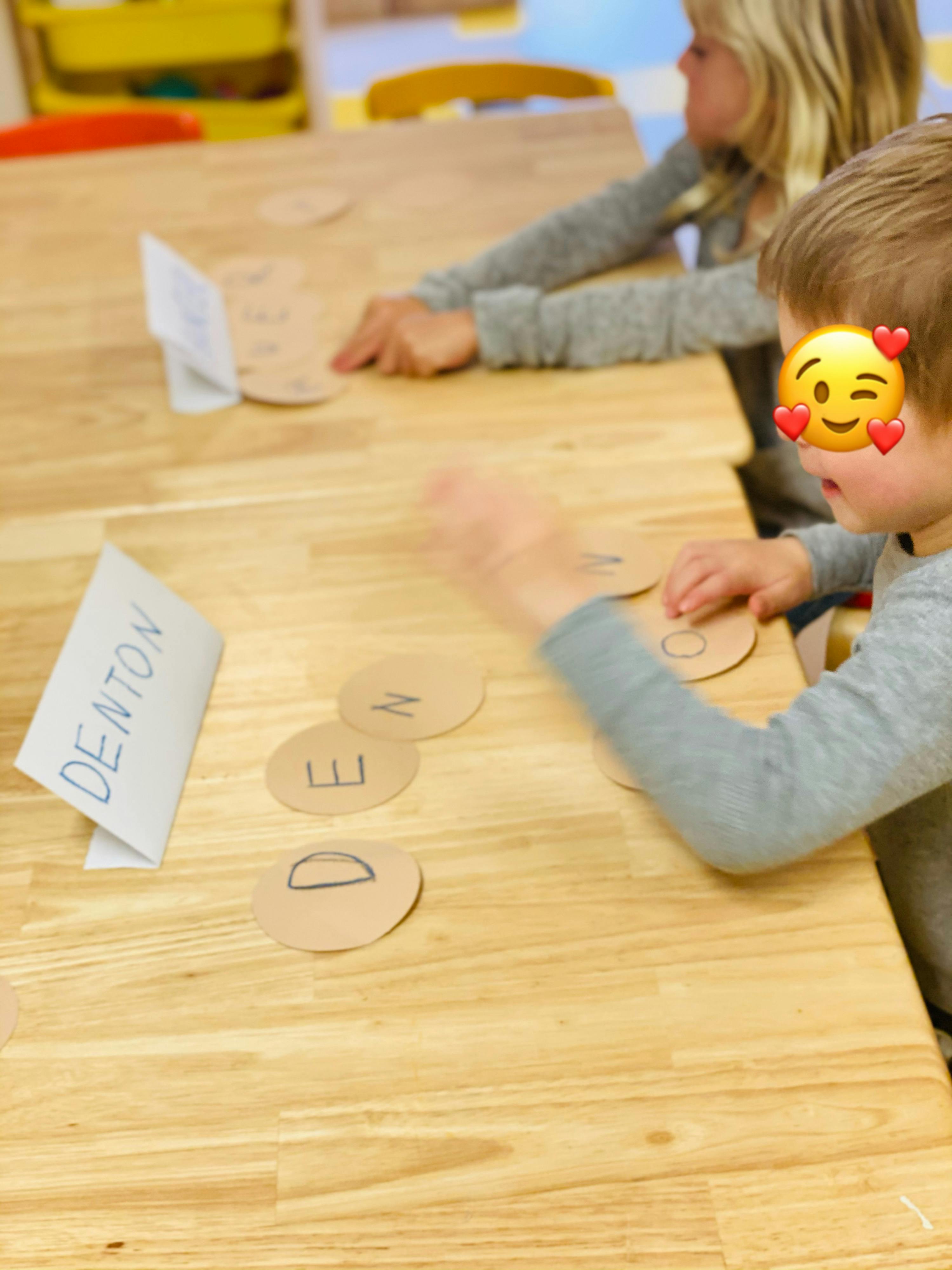 Child playing with letter cutouts at a table