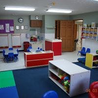 Empty classroom with small tables and storage units