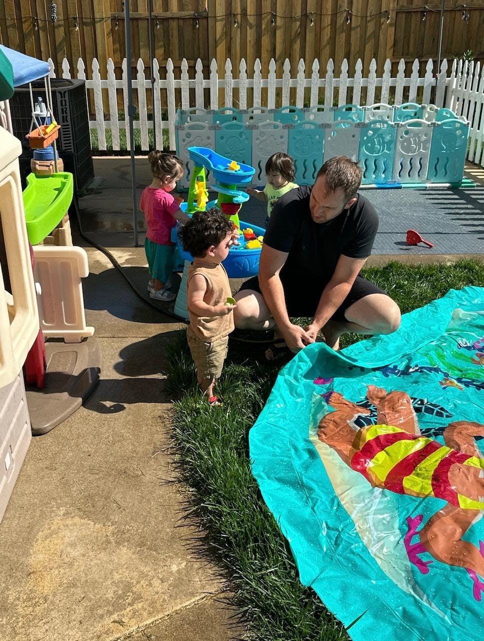 Adult and children playing with water toys outdoors
