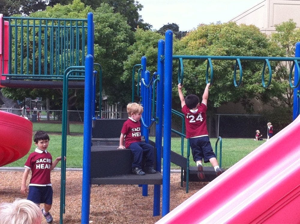 Three children playing on a playground structure