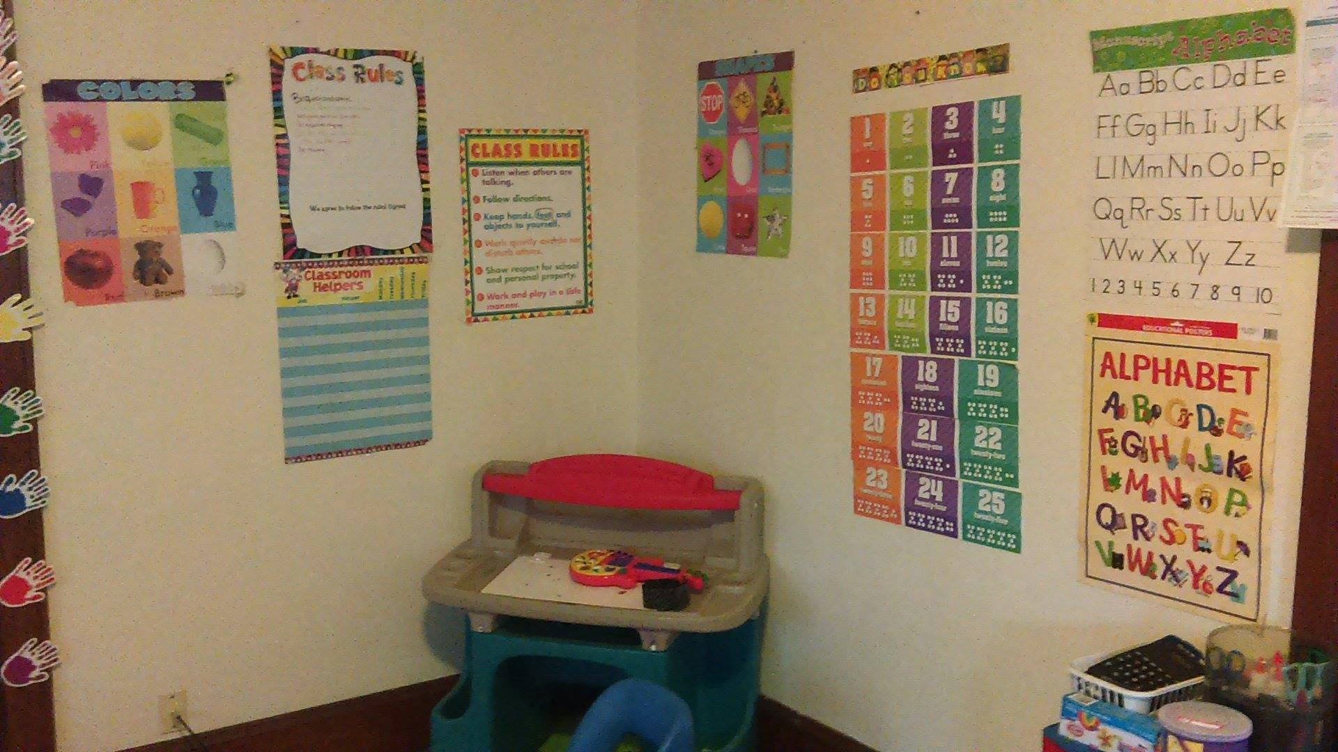 Classroom corner with educational posters and a child's desk