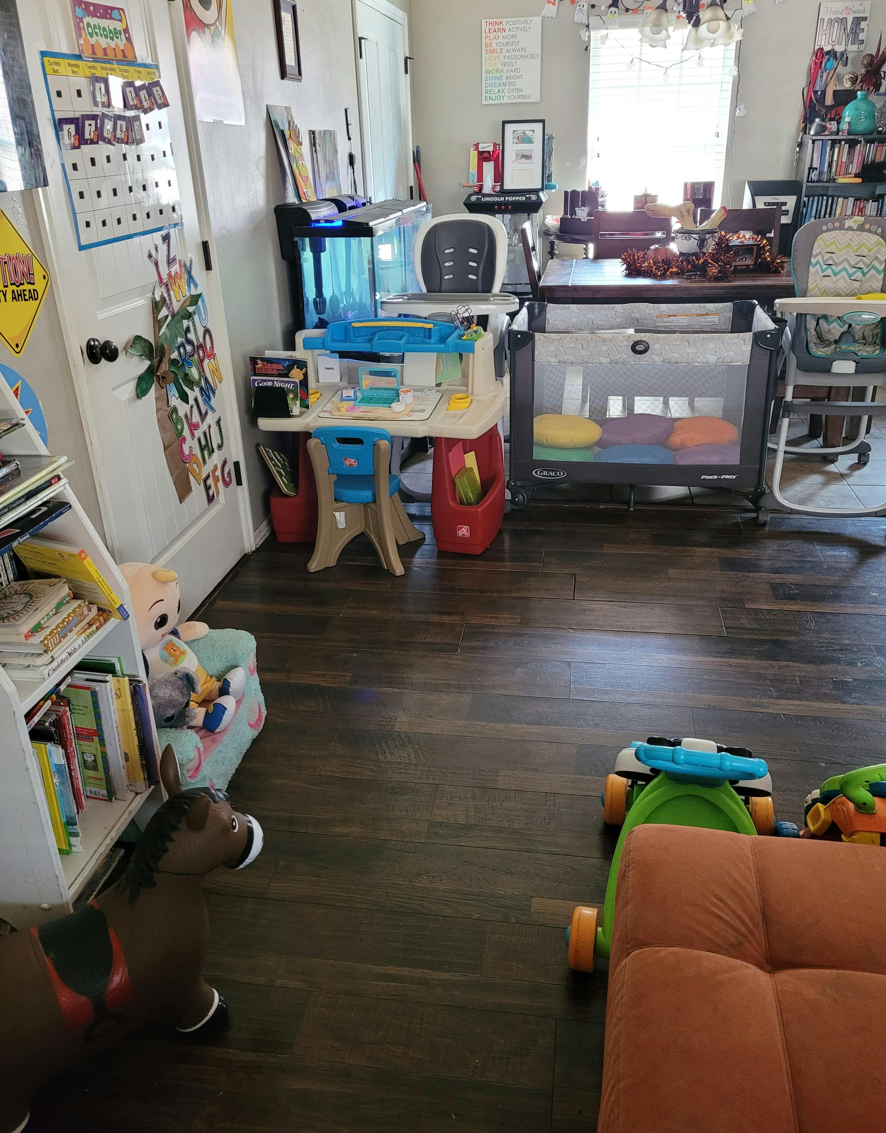 Playroom with children's furniture, toys, and a crib