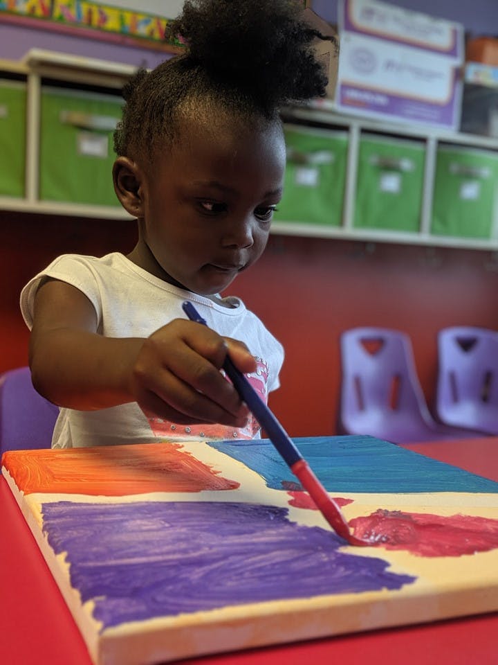 Child painting on a canvas with a brush