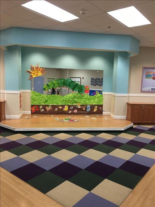 Stage area in a room with a large cutout of The Very Hungry Caterpillar