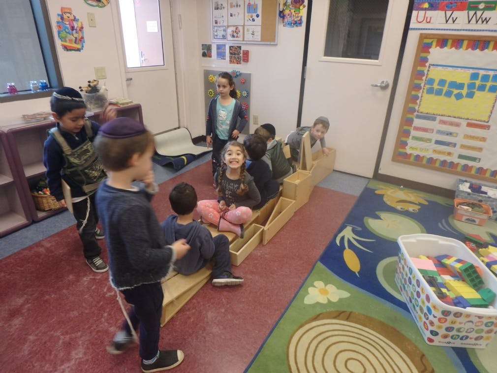 Children playing with wooden blocks in a classroom