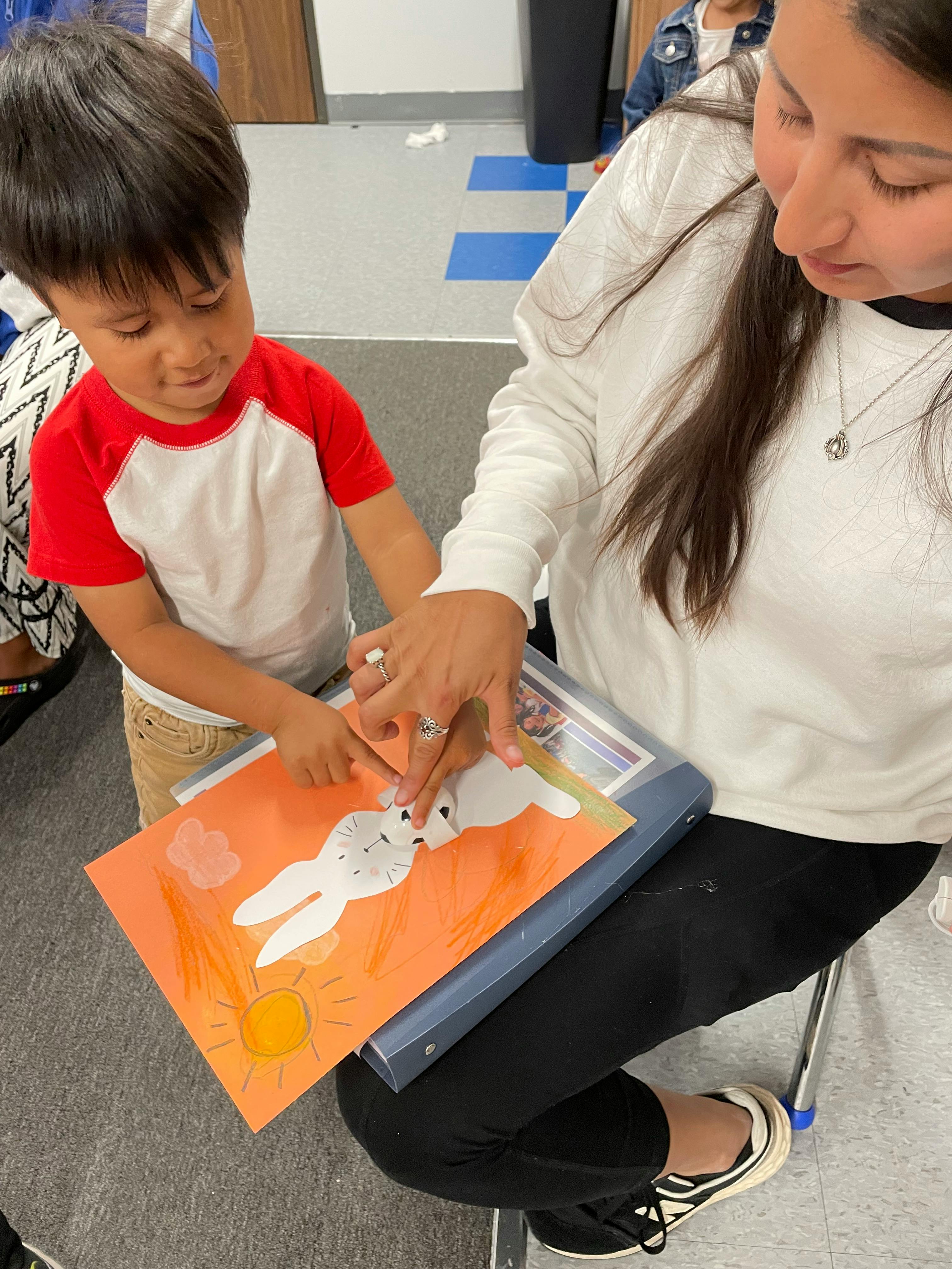 Adult and child pointing at a drawing of a rabbit