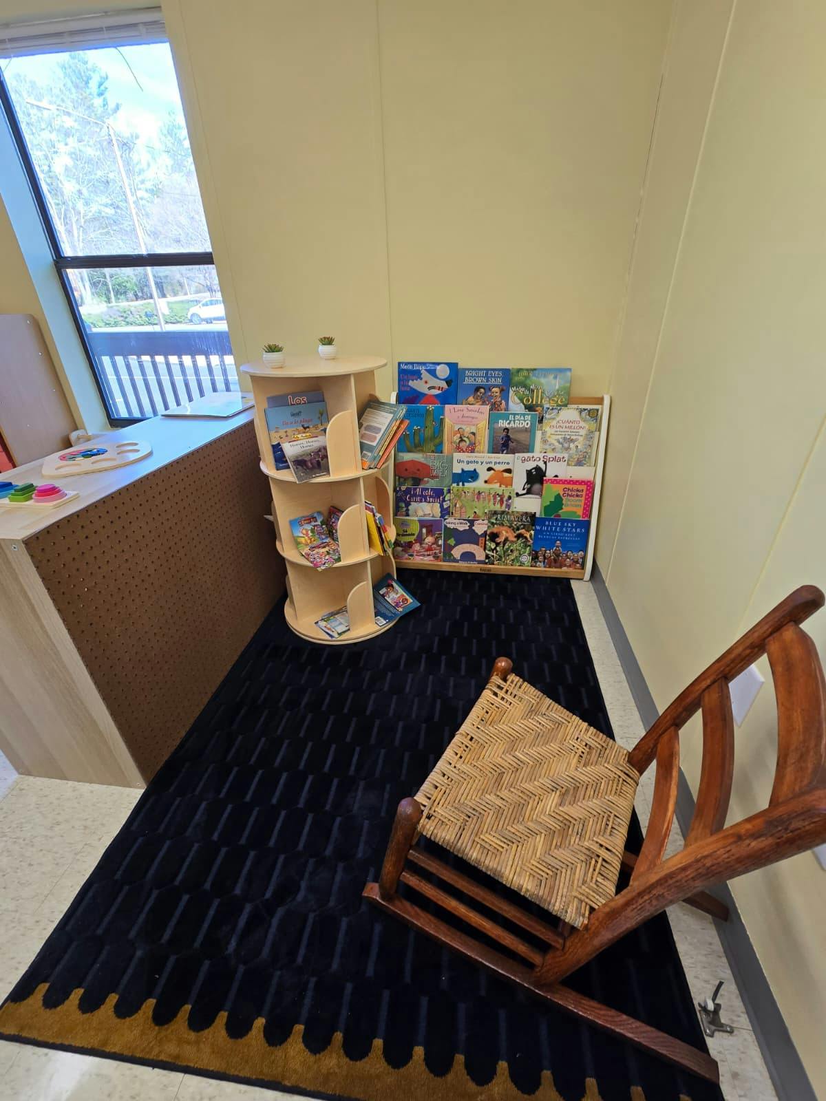 Small wooden rocking chair facing a display of children's books
