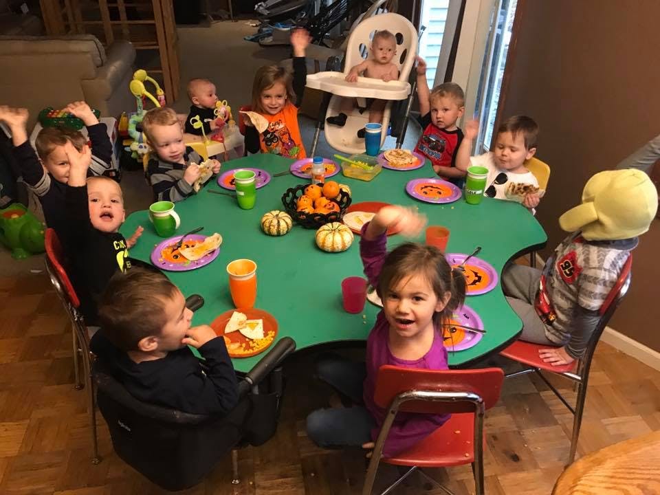Multiple children sitting around a table with food and pumpkins