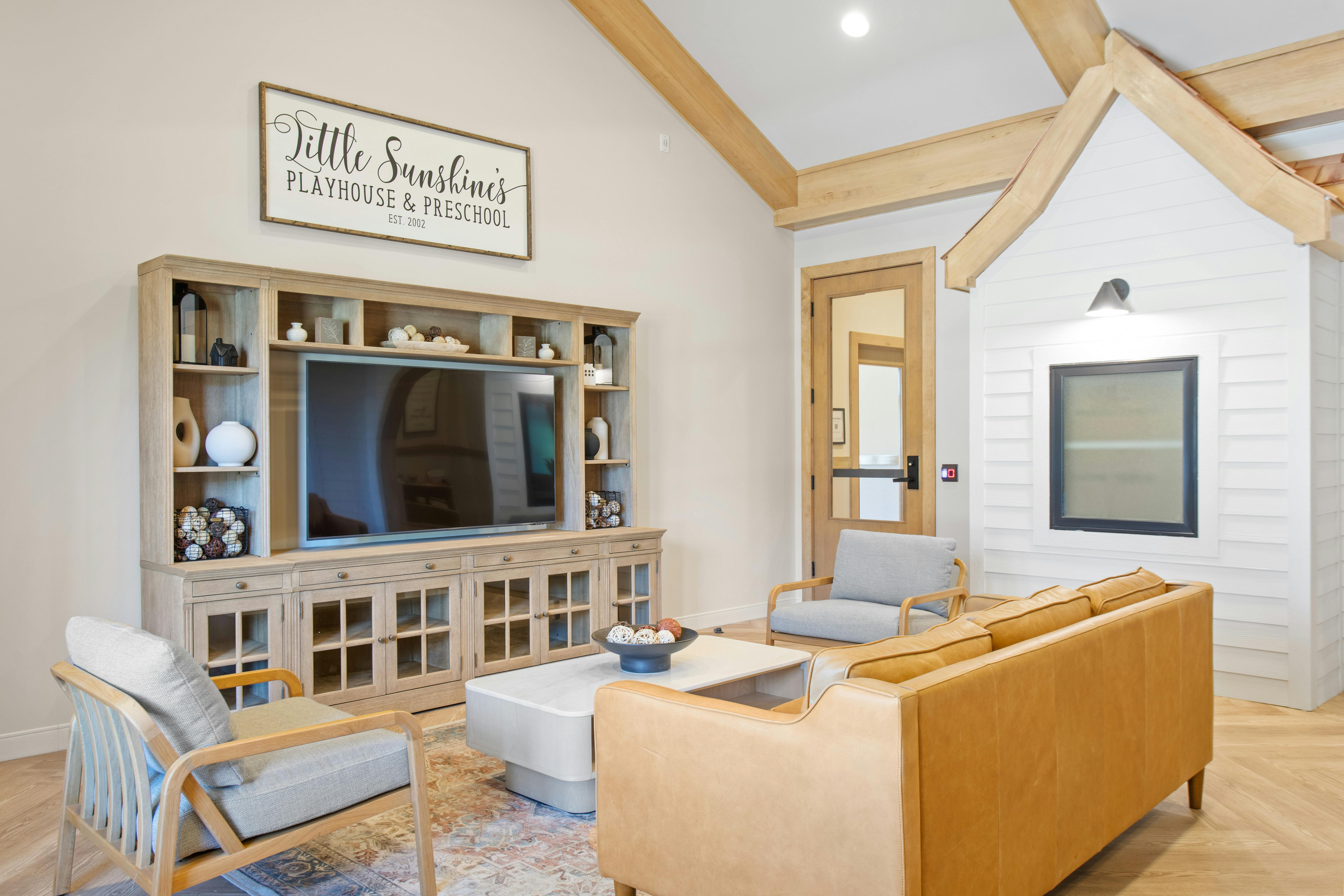 Living room with a large TV console, sofa, and chairs