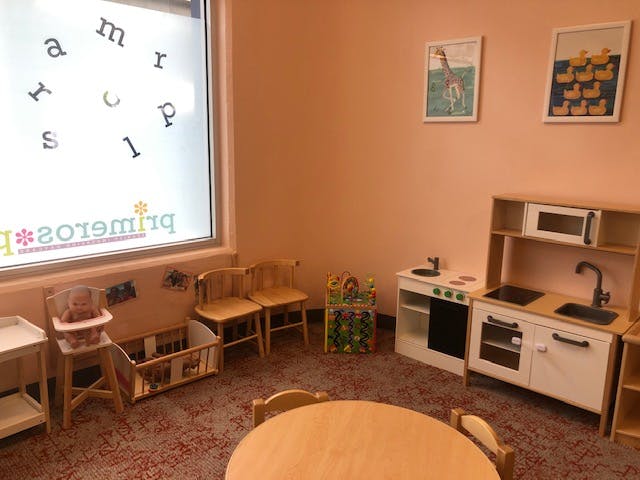 Playroom with toy kitchen, small chairs, and a table