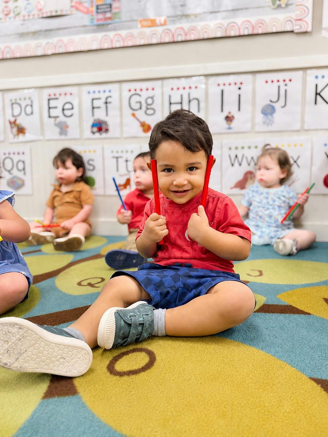 Child holding percussion sticks in a classroom setting