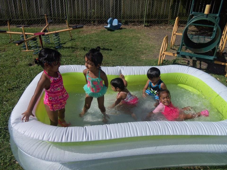 Children playing in an inflatable pool outdoors