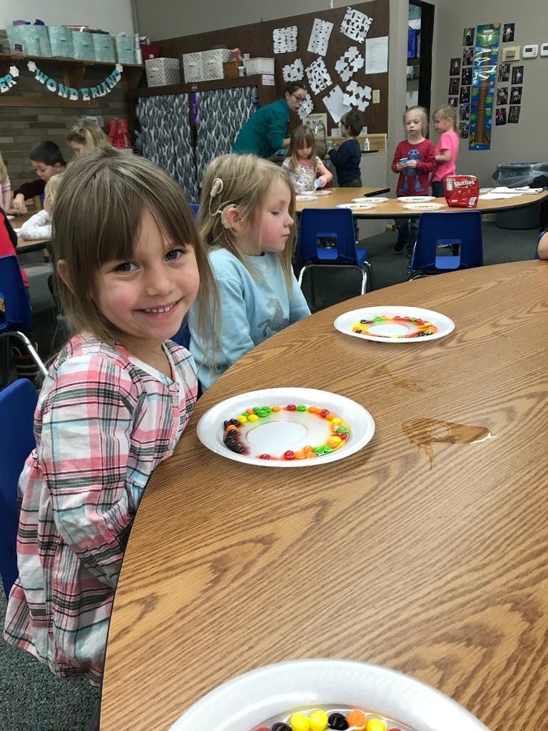 Child smiling at a table with candy on plates