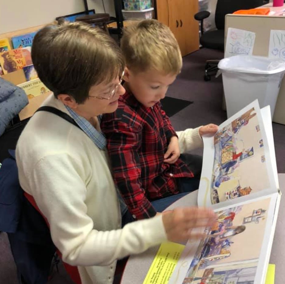 Person and child looking at an open book