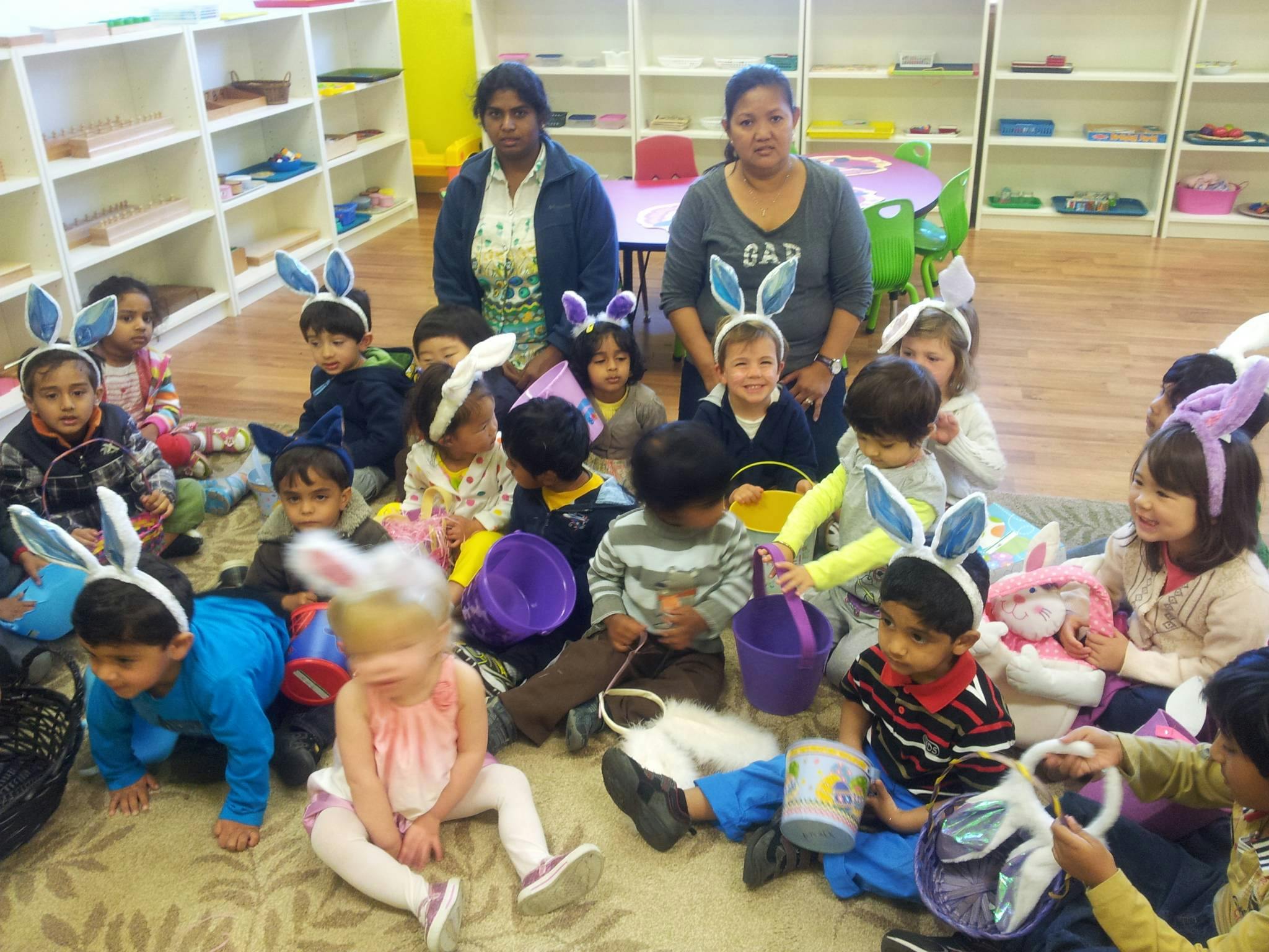 Two people with a group of children wearing bunny ears