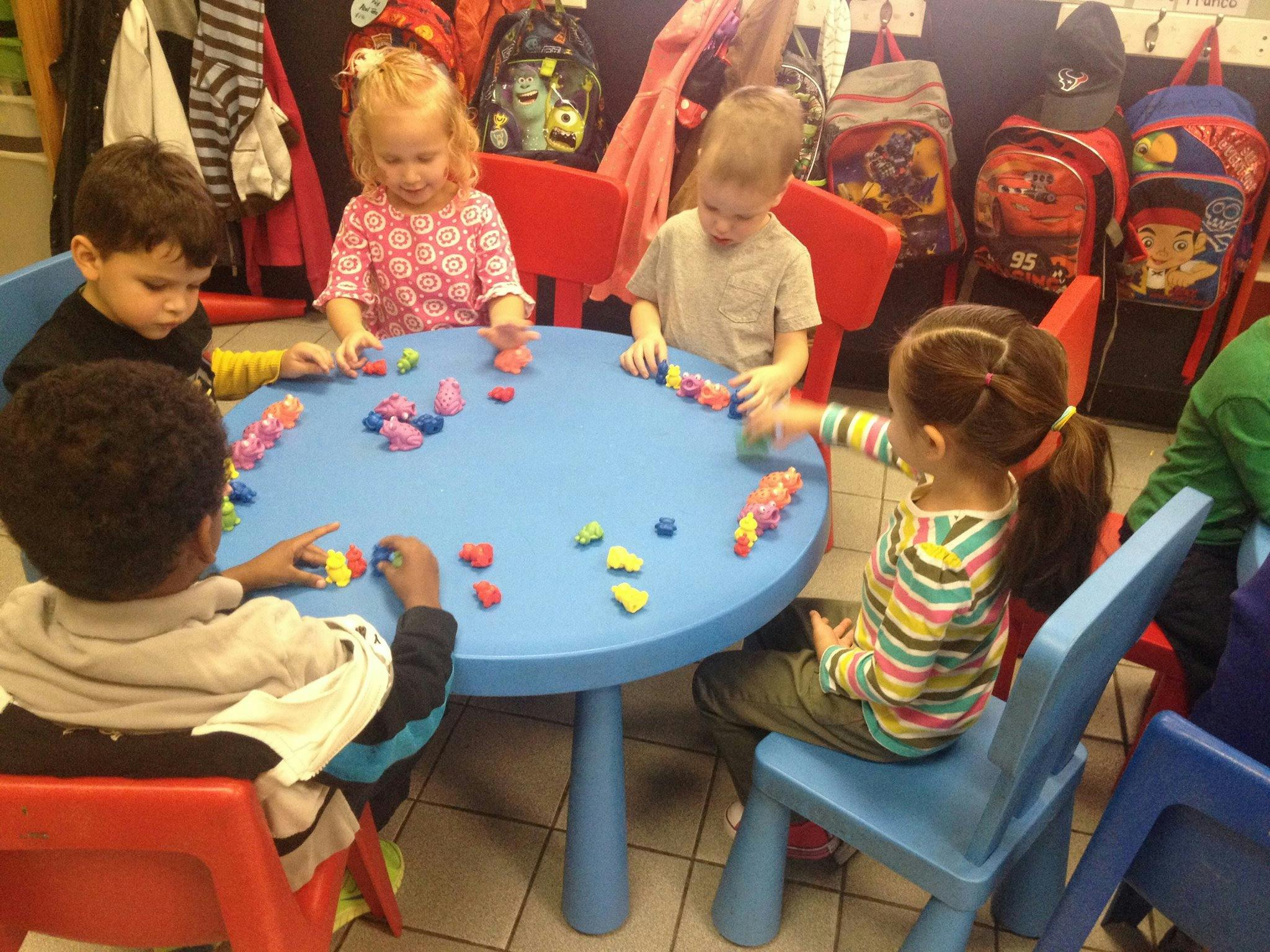 Children playing with colorful blocks at a blue table