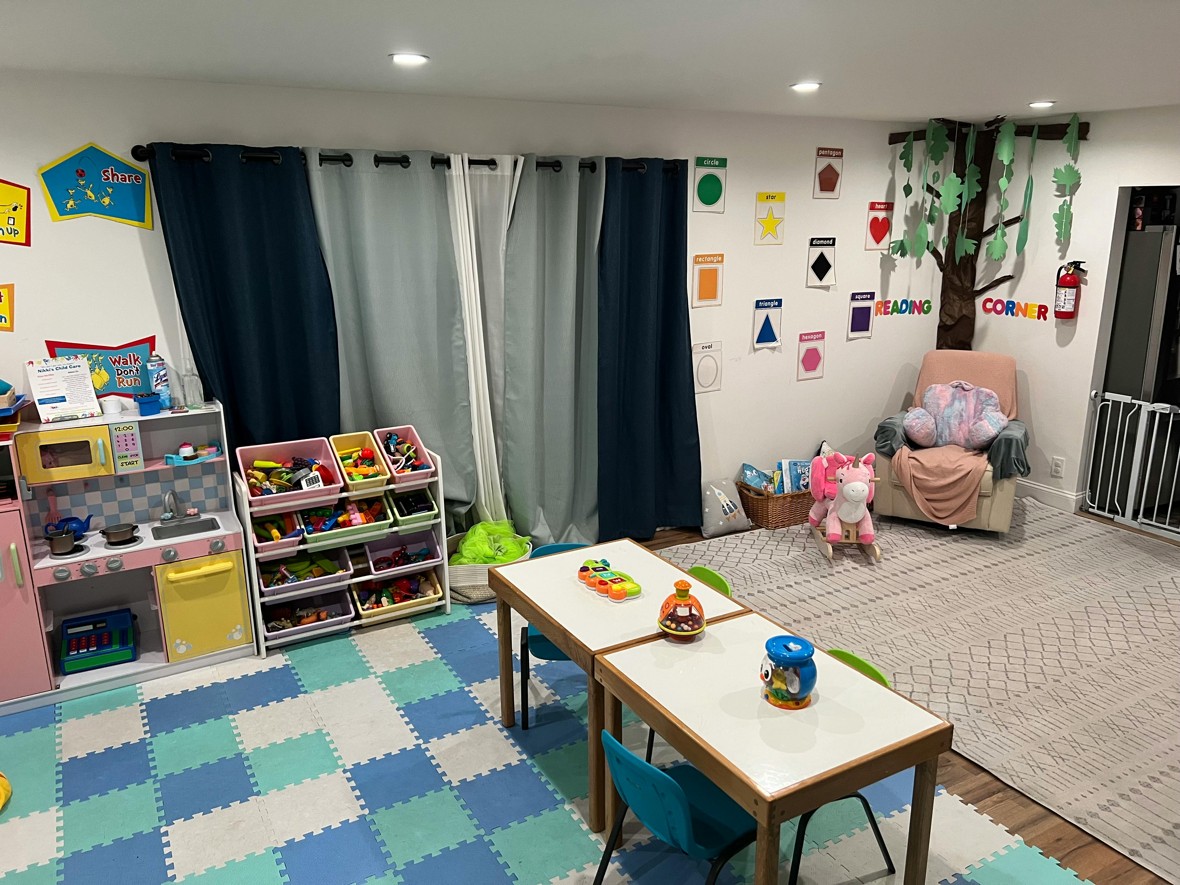 Playroom with small tables and chairs, toy storage, and a reading corner