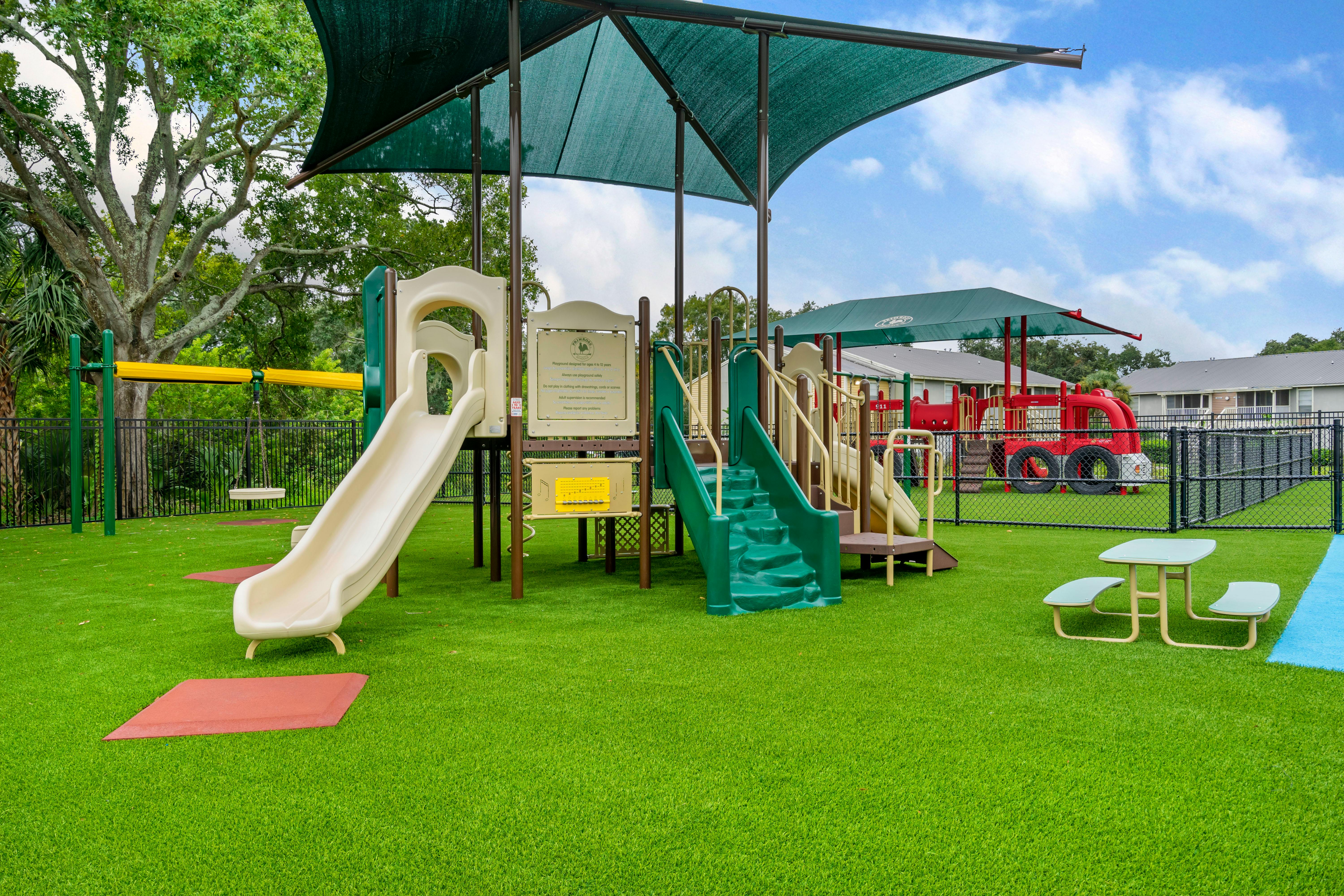 A colorful outdoor playground with slides, swings, and a picnic table