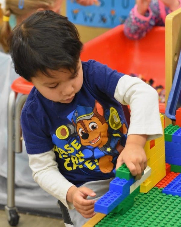 Child playing with colorful building blocks