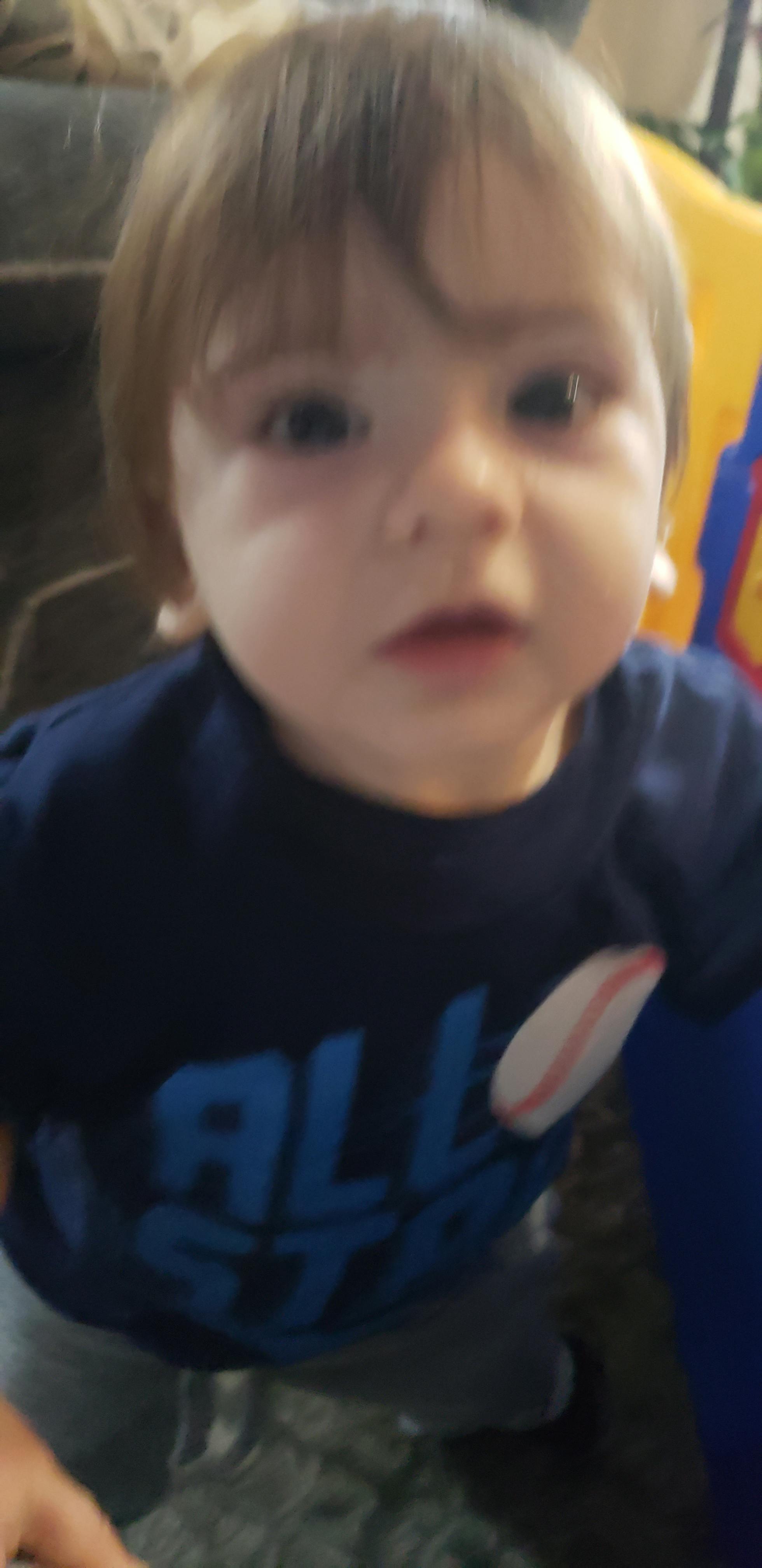 Child with light brown hair wearing a blue shirt