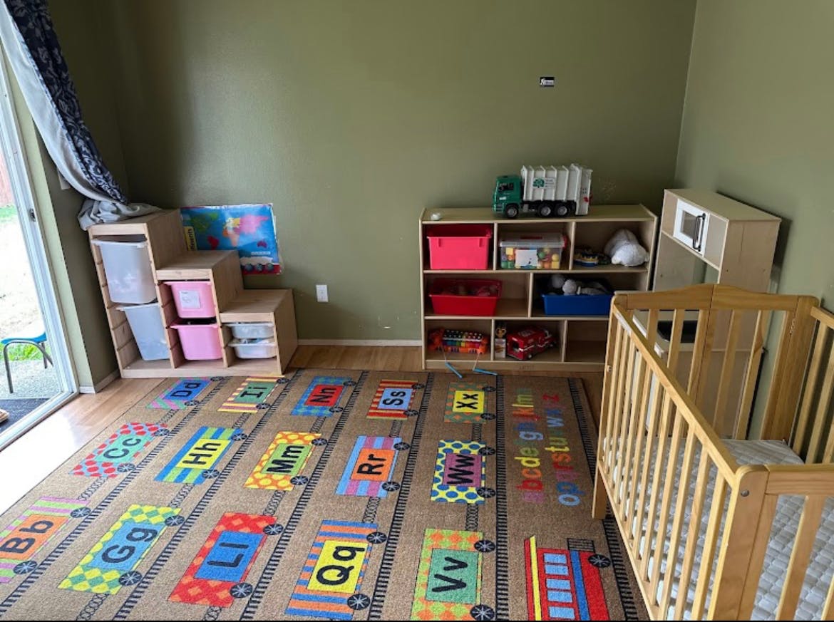 Nursery room with crib, toy shelves, and alphabet rug