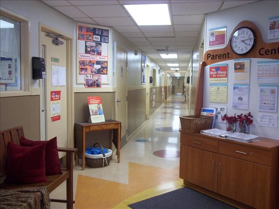 Hallway in a childcare center with bulletin boards and furniture