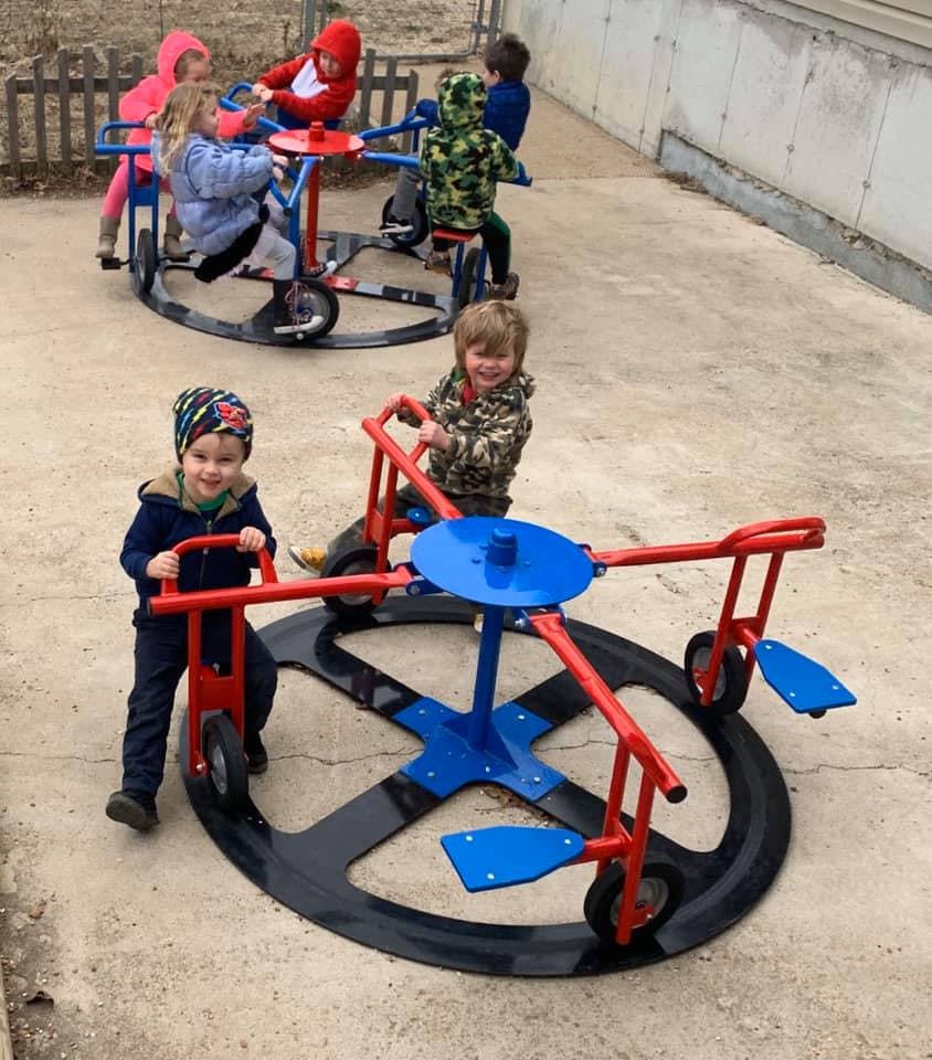 Children playing on a playground merry-go-round